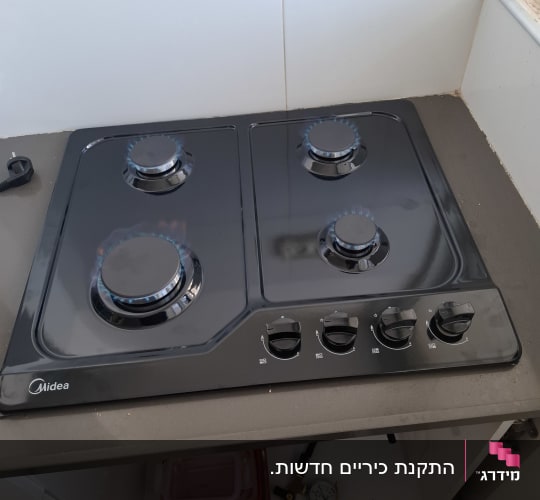 כיריים גז שחורים במטבח עם להבות כחולות